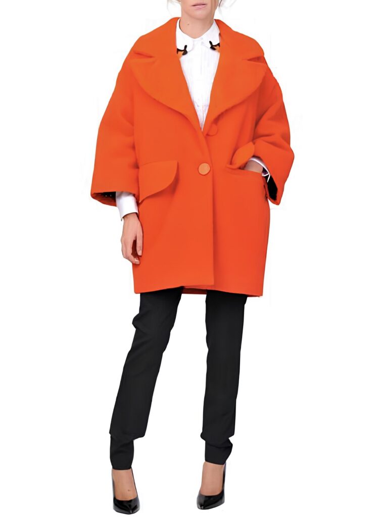 A fashion photo from suite123 archive of a model wearing an oversized, orange coat made of Panno Casentino wool. The coat is worn over a crisp white shirt and black straight-leg trousers, all against a clean white background.